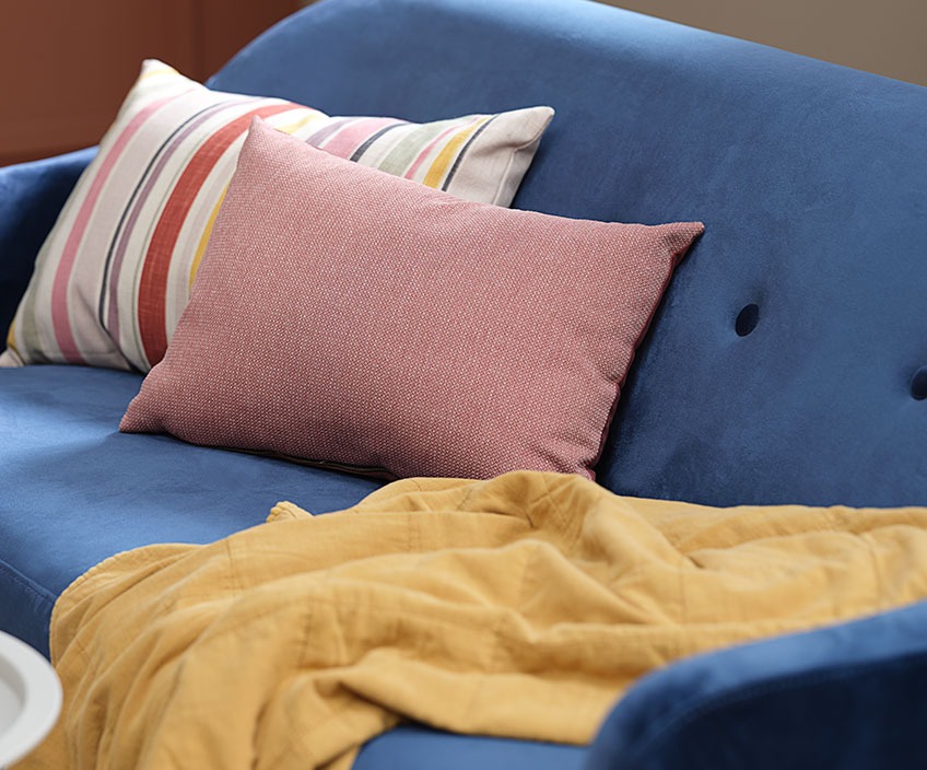 Πολύχρωμα μαξιλαράκια και κάλυμμα κρεβατιού σε κίτρινο χρώμα πάνω σε καναπέ