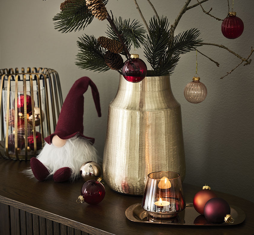 Κηροπήγιο σε χρυσό χρώμα, χριστουγεννιάτικα ξωτικά και βάζο σε χρυσό χρώμα με κλαδιά ελάτου και χριστουγεννιάτικες μπάλες