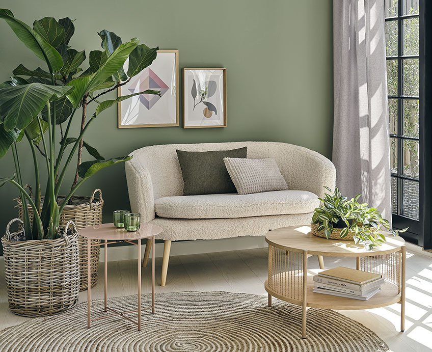 Καθιστικό με λευκό καναπέ, τραπεζάκι σαλονιού σε δρύινο χρώμα και πράσινα φυτά