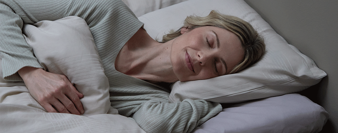 Γυναίκα που κοιμάται στο πλάι με πάπλωμα και μαξιλάρι