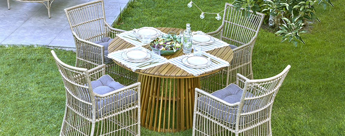 Στρογγυλό τραπέζι κήπου και τέσσερις καρέκλες κήπου σε κήπο