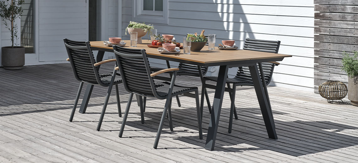 Τραπέζι κήπου με μαύρα μεταλλικά πόδια και ξύλινη επιφάνεια και 4 καρέκλες κήπου σε αίθριο