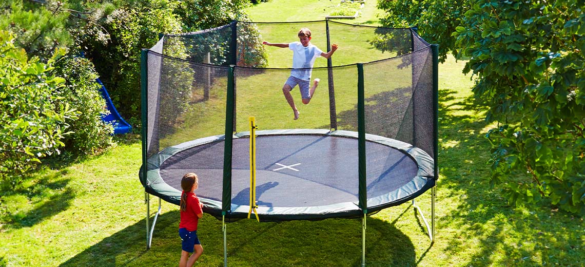 Παιδιά που παίζουν σε μεγάλο τραμπολίνο στον κήπο