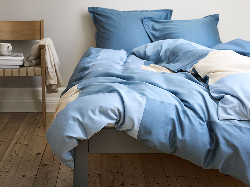 Κρεβάτι στρωμένο με βαμβακερό σετ παπλωματοθήκης σε μπλε απόχρωση