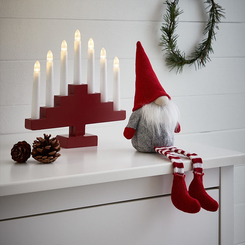 Χριστουγεννιάτικο ξωτικό με λευκή γενειάδα, μυτερό κόκκινο καπέλο και ριγέ κάλτσες