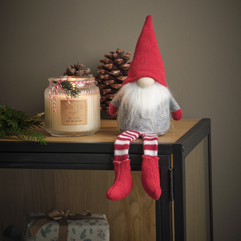 Χριστουγεννιάτικο ξωτικό με λευκή γενειάδα, κόκκινο μυτερό καπέλο και ριγέ κάλτσες