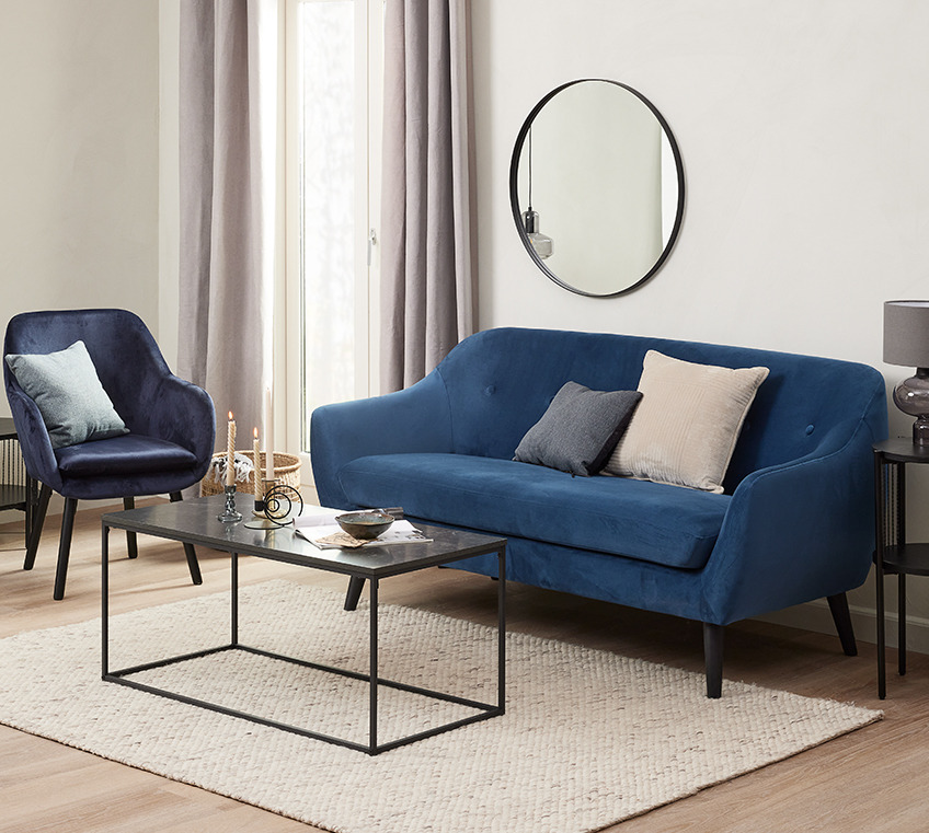 Στρογγυλός καθρέφτης στο σαλόνι πάνω από μπλε καναπέ