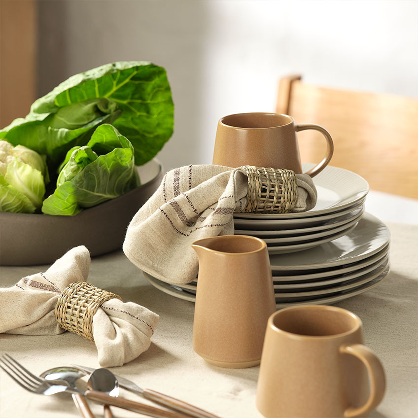 Είδη κουζίνας: Κούπα, γαλατιέρα, πετσέτες φαγητού και μπολ σαλάτας σε τραπέζι