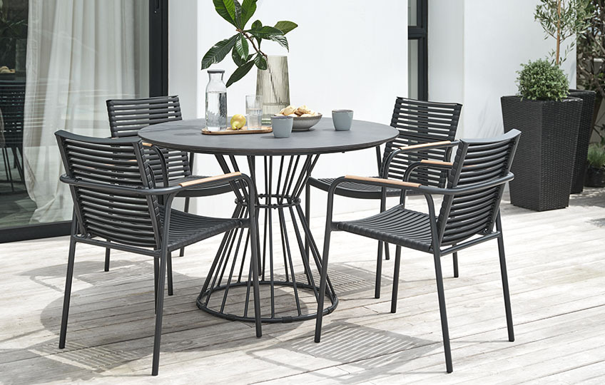 Στρογγυλό τραπέζι κήπου με επιφάνεια από ίνες τσιμέντου και πλαστικές καρέκλες κήπου