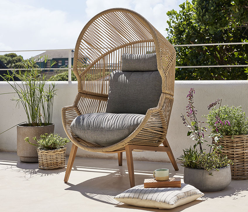 Μεγάλη καρέκλα σαλονιού κήπου σε ένα ηλιόλουστο μπαλκόνι