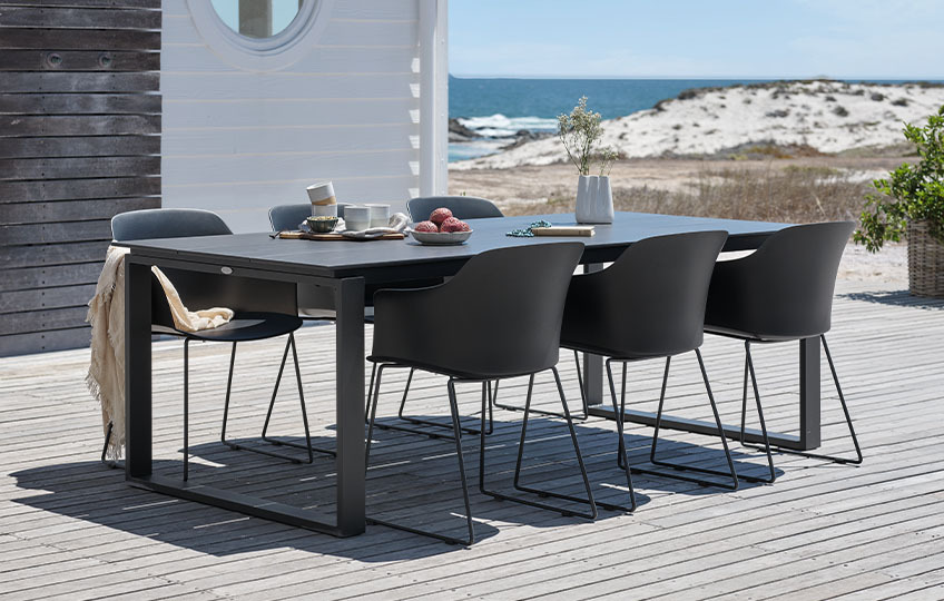 Μεγάλο τραπέζι κήπου και καρέκλες σε αίθριο δίπλα σε παραλία