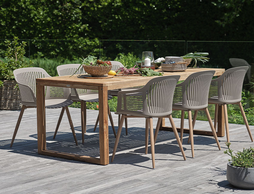 Τραπέζι κήπου από σκληρό ξύλο και καρέκλες κήπου σε αίθριο σε αυλή