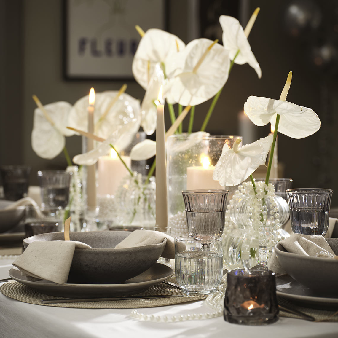 Τραπέζι διακοσμημένο με μπολ, πιάτα, ποτήρια, κηροπήγια και βάσεις ρεσό