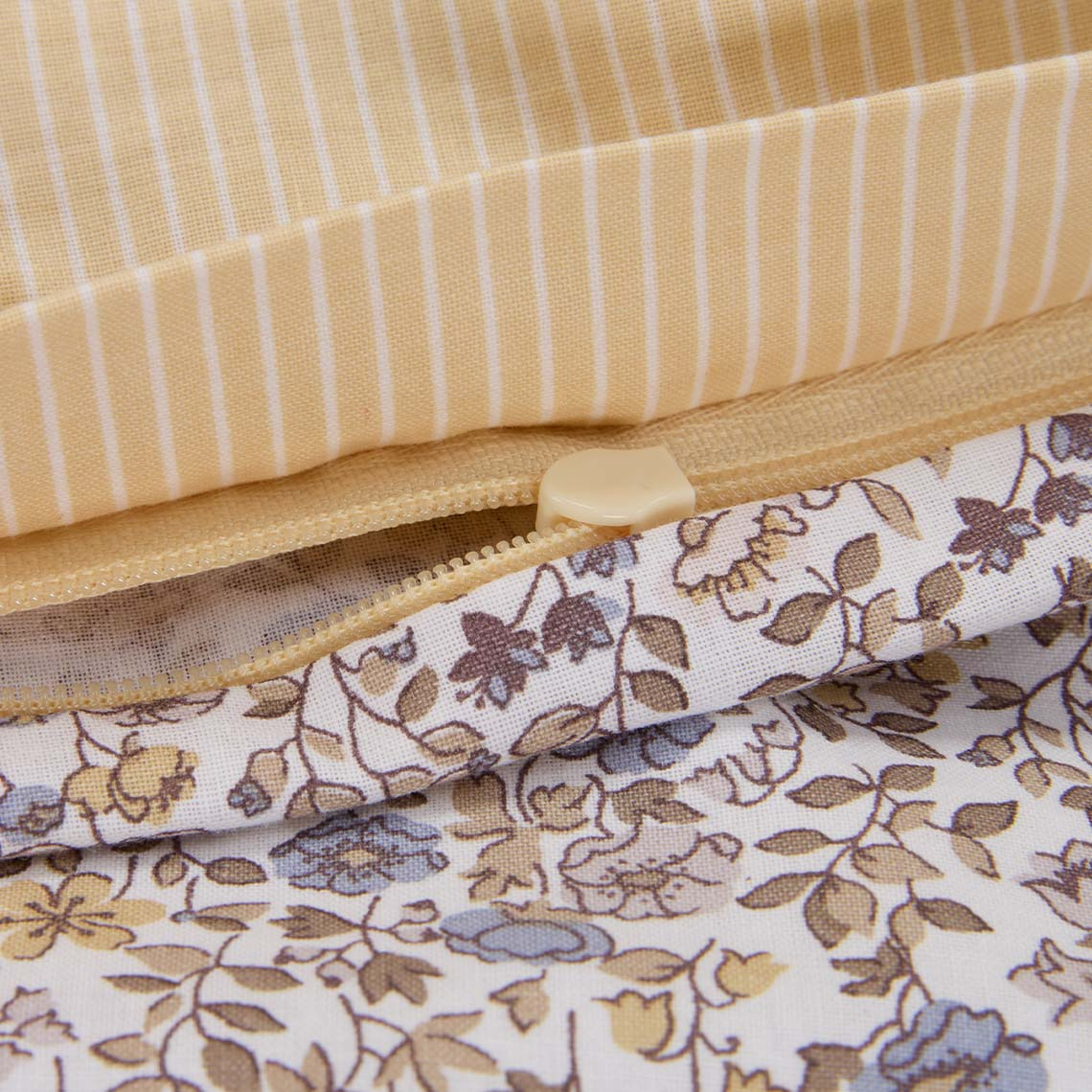 Το σετ παπλωματοθήκης NIKOLINE Κλινοσκεπάσματα από βαμβάκι, με μικρά παστέλ λουλούδια σε αποχρώσεις του μωβ και του κίτρινου.