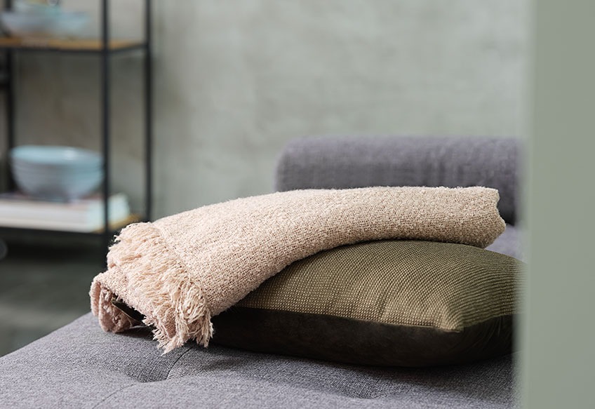 Ριχτάρι και διακοσμητικό μαξιλάρι πάνω σε καναπέ
