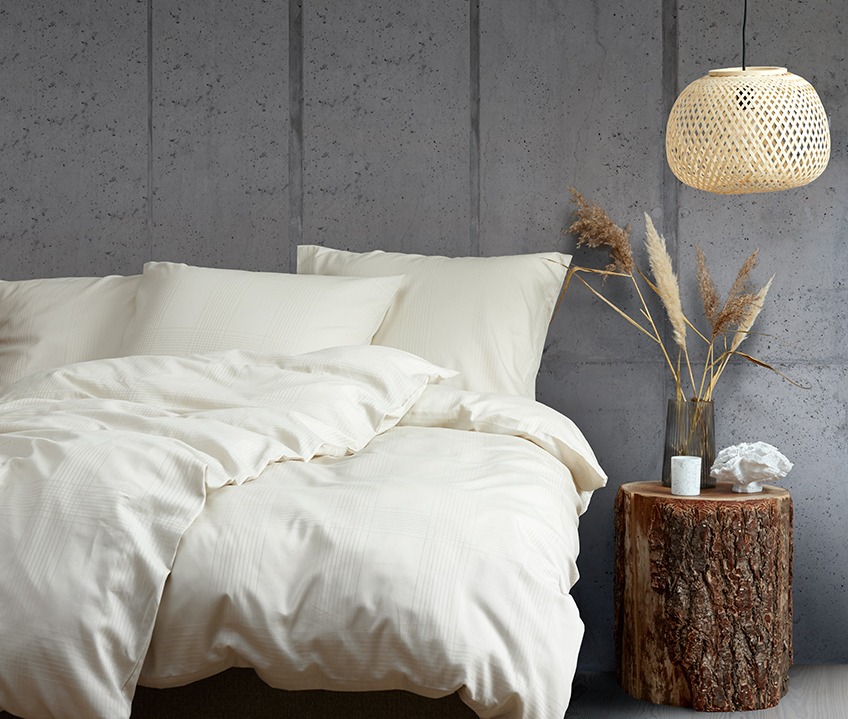 Κομψό υπνοδωμάτιο με μια ήρεμη Σκανδιναβική εμφάνιση και κρεβάτι στρωμένο με παπλωματοθήκη στο χρώμα της άμμου