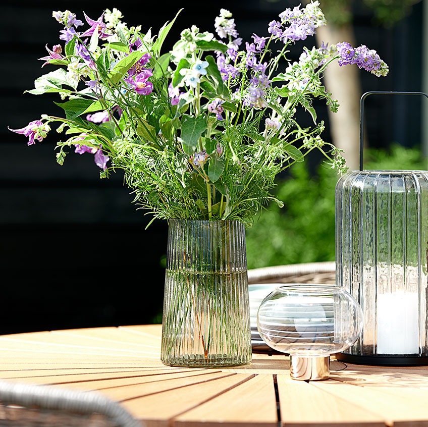 Γυάλινο βάζο & φανάρι κήπου πάνω σε στρογγυλό τραπέζι κήπου