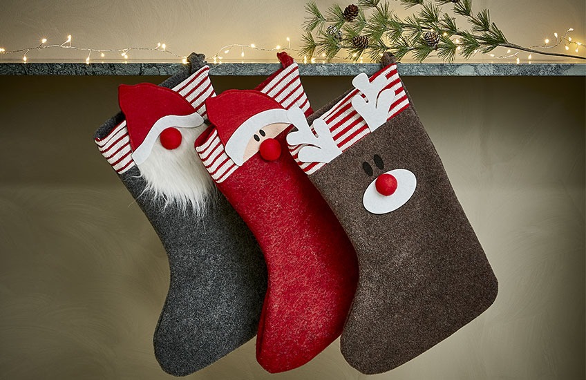 Χριστουγεννιάτικες κάλτσες κρεμασμένες σε ράφι με χριστουγεννιάτικα σχέδια