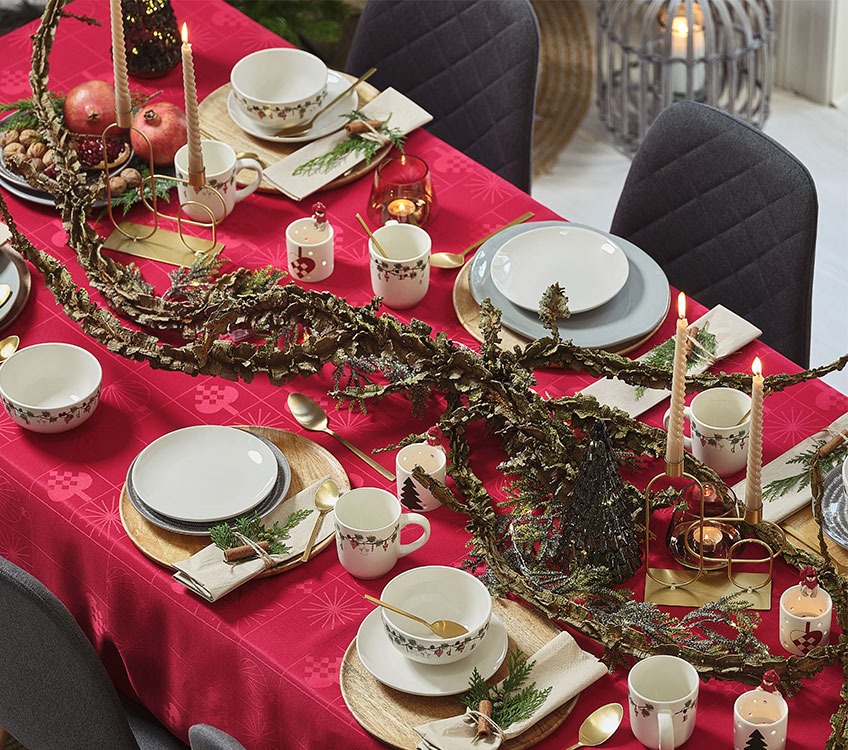 Τραπέζι με χριστουγεννιάτικη διακόσμηση σε χρυσές αποχρώσεις και κόκκινο τραπεζόμαντηλο 