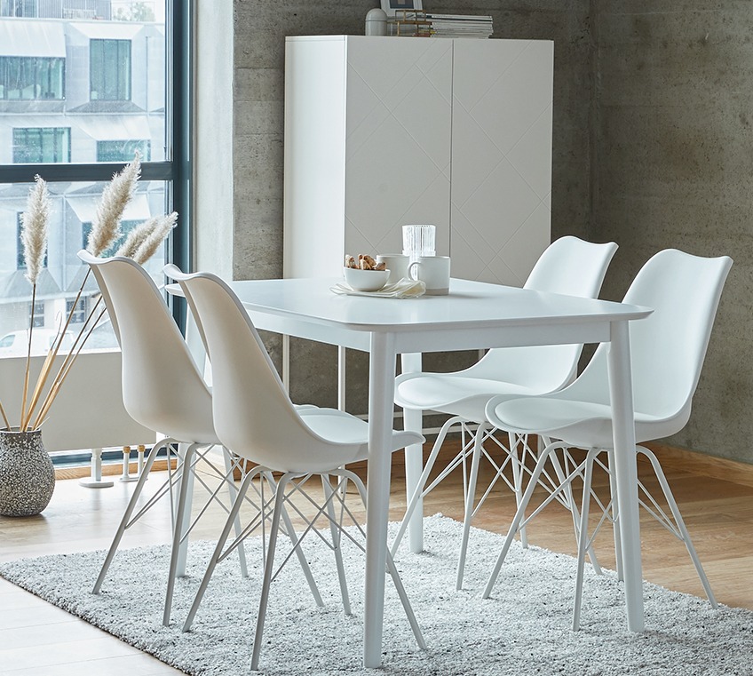 Τέσσερις λευκές καρέκλες τραπεζαρίας γύρω από το τραπέζι