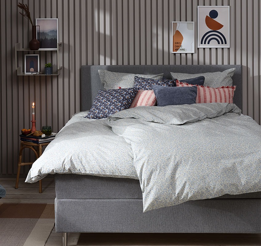 Κρεβάτι στρωμένο με φλοράλ σετ παπλωματοθήκης και διακοσμητικά μαξιλάρια σε μπλε και ροζ αποχρώσεις