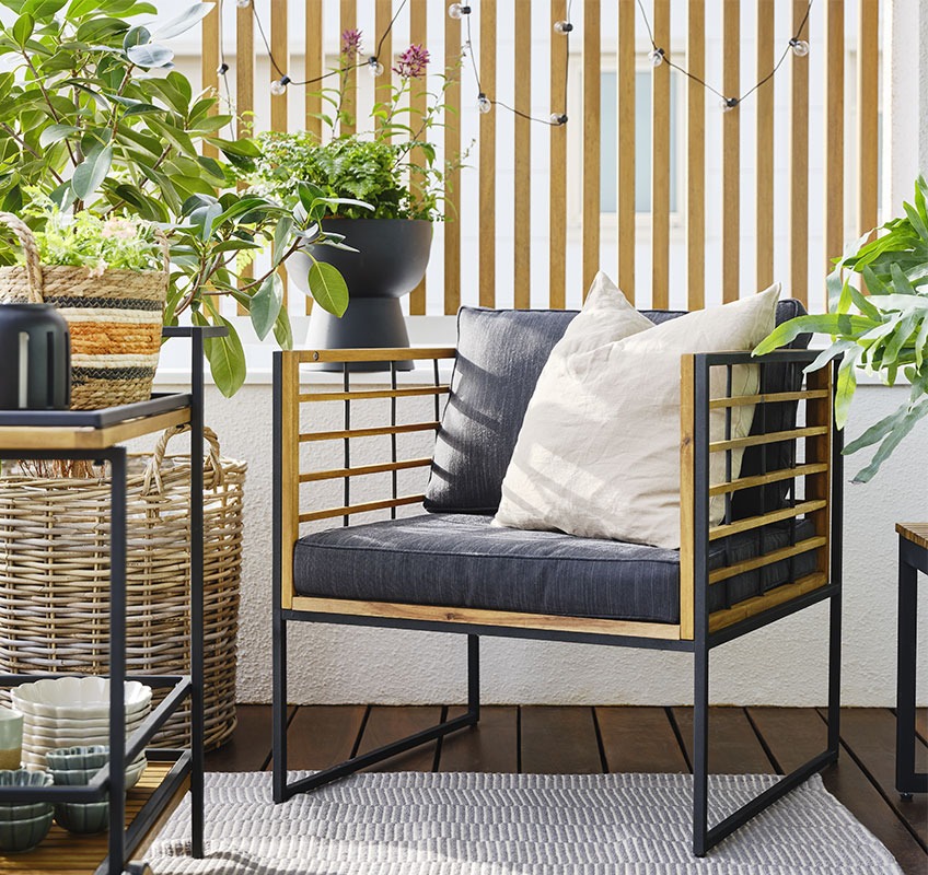 Μπαλκόνι με καρέκλα σαλονιού κήπου με ξύλο και μεταλλικό μαύρο σκελετό και πράσινα φυτά