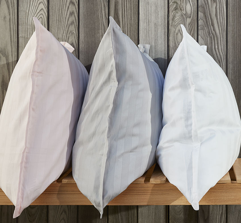 Τρία μαξιλάρια με μαξιλαροθήκες σε τριανταφυλλί, γκρι και λευκό χρώμα